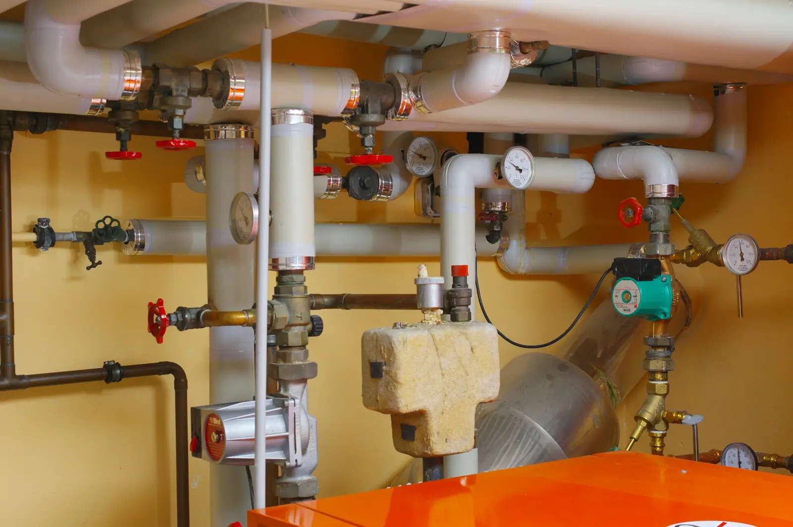 Heizungsraum mit Rohren, Ventilen und Pumpen
